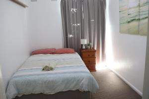 a bedroom with a bed and a dresser and a window at The Sundown Stay in Dubbo