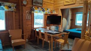 a dining room with a table and a television in a cabin at Kaijonselän mökit Kaita in Kaitainen