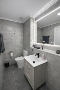 a bathroom with a sink and a toilet and a mirror at Casa Silva Diamond in Pinhal Novo