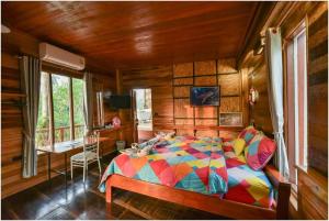 a bedroom with a colorful bed in a wooden room at Tamsabai Resort in Ban Na Nian +106 photos