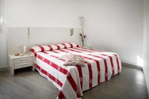 a bed with a red and white striped blanket in a bedroom at Cala Palme Lampedusa in Lampedusa