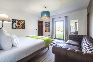 a bedroom with a large bed and a couch at Quinta da Morgadia - Private Ocean View Estate in Feteiras