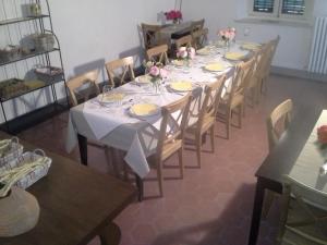 Cascina Barosca في Castelnuovo Don Bosco: طاولة طويلة عليها كراسي وصحون وزهور
