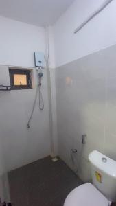 a bathroom with a white toilet and a window at Maison d'hôtes Jaxaay in Keur Massar