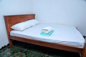 a bed with a book with a white towel on it at Jaffna Bungalow in Jaffna