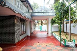 a hallway of a building with a red tile floor at Jaffna Bungalow in Jaffna +16 photos