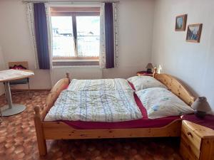 a bedroom with a bed with a wooden frame and a window at Ferienwohnung Feicht`n Schuster in Gosau
