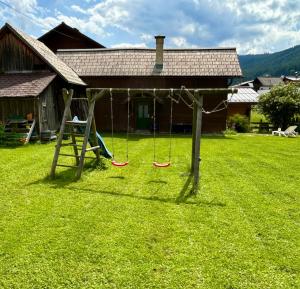 a swing set in a yard in front of a house at Ferienwohnung Feicht`n Schuster in Gosau