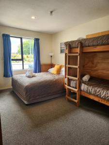 a bedroom with two bunk beds and a window at Snow Denn Lodge in Methven