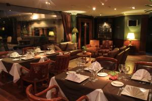 - un restaurant avec des tables, des chaises et un canapé dans l'établissement Premier Hill Suites Hotel, à Asuncion
