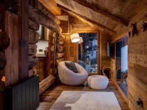 a log cabin living room with a couch and a chair at Alpine Majestic Rascard - Unique Mountain Experience with Balcony and panoramic views in Champoluc