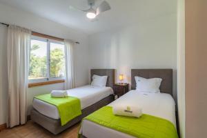 a bedroom with two beds and a window at Unforgettable Ocean Views-Spacious Seaside Villa in Mosteiros