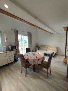 a room with a table and chairs and a bed at Entre Terre et Camargue- Studio de Charme in Le Cailar