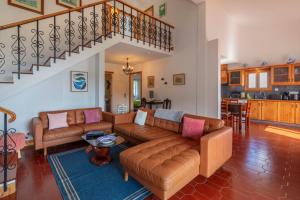a living room with couches and a staircase at Unforgettable Ocean Views-Spacious Seaside Villa in Mosteiros