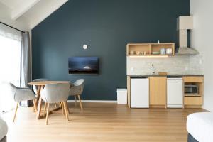 a kitchen with blue walls and a table and chairs at Mt Wellington Motel in Auckland +25 photos