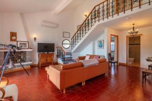 a living room with a couch and a staircase at Unforgettable Ocean Views-Spacious Seaside Villa in Mosteiros