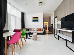 a living room with a couch and a table and chairs at MUN HOMESTAY in Hue