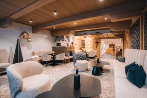 a lobby with couches and tables and chairs at Hotel Edelweiss in Kaunertal