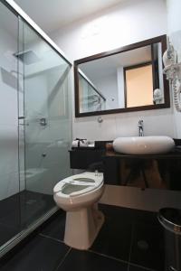 a bathroom with a toilet and a sink and a mirror at Hotel Kahvé in Garzón