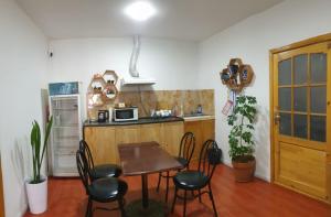 a kitchen with a table and chairs and a kitchen with a microwave at Bee Happy Hostel & Gobi amazing tour in Dalandzadgad +26 photos