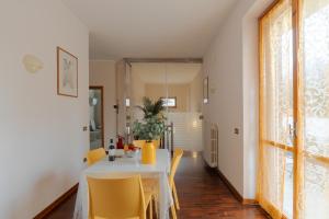 a dining room with a table and yellow chairs at Villa Pia in Bevagna