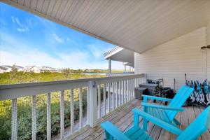 a porch with two blue chairs and a grill at Beach Access & Heated Pool Resort Condo for 8 in Clearwater Beach