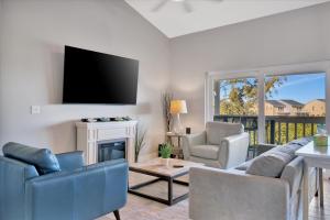 a living room with a couch and a tv at Beach Access & Heated Pool Resort Condo for 8 in Clearwater Beach