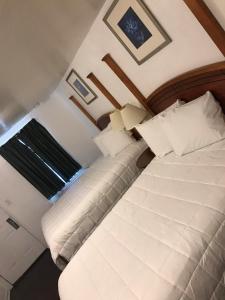 1 dormitorio con 1 cama con sábanas y almohadas blancas en Extended Stay Studios en Montgomery