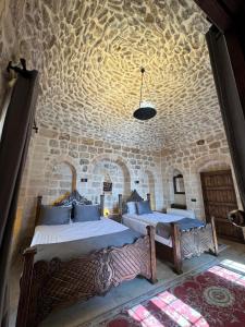 a bedroom with two beds and a stone wall at Sıla Konağı Hotel in Mardin