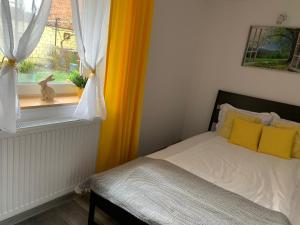 a bedroom with a bed with yellow pillows and a window at Casa JOY in Râşnov