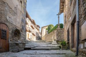 an alley in an old town with stone buildings at Apartaments Can Lo in Rupit