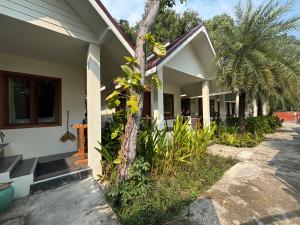 a house with a palm tree in front of it at Diamond Beach Resort in Ko Samed