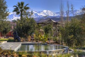 a statue of a dog in a garden with mountains in the background at The Ranch Camp in El Karia