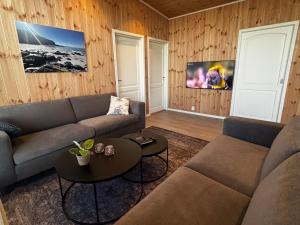 a living room with a couch and a table at Unik og moderne hytte med utsikt mot havet 38 Otterlei Resort in Haram