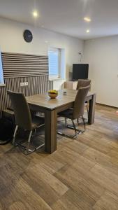 a dining room with a wooden table and chairs at Moni's Ferienwohnung in Hammelburg +9 photos