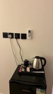 a stove with a tea kettle on top of a refrigerator at استديو in Medina