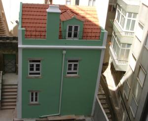 een groen gebouw in het midden van twee gebouwen bij Apartamento Sapato in Lissabon