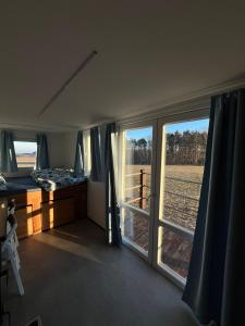 a bedroom with a bed and a window with a view of a field at Maringotka uprostřed divočiny in Proseč