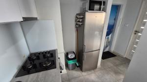 a kitchen with a stainless steel refrigerator with a microwave at Apartament WAGABUNDA in Wałbrzych