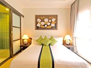 a bedroom with a large white bed with green pillows at The Sea View Residence in Ban Bang Bao