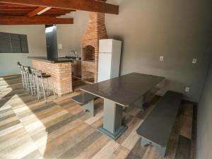 a dining room with a table and a kitchen at Recanto do entardecer in Socorro