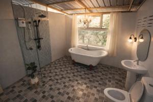 a bathroom with a tub and two toilets and a sink at แม่ไพโฮมสเตย์ ล่องแพกอนโดล่า in Ban Racha Tai