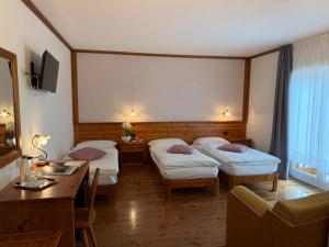 a hotel room with two beds and a table at Hotel Garni Civetta in Selva di Cadore +61 photos