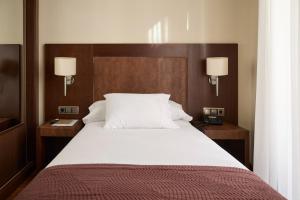 a bedroom with a large white bed with two night stands at Layana1925 in Aranda de Duero