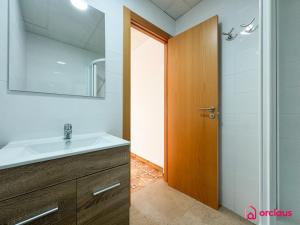 a bathroom with a sink and a wooden door at El Mini Piso in San Juan de Moró