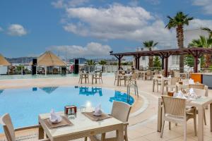 a restaurant with tables and chairs next to a pool at Diamond Of Bodrum in Bodrum City