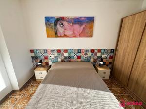 a bedroom with a bed and a painting on the wall at El Mini Piso in San Juan de Moró