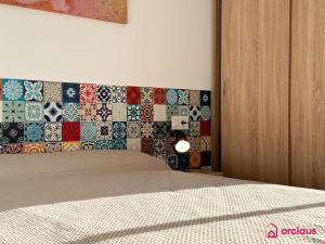 a bedroom with a bed with a wall covered in tiles at El Mini Piso in San Juan de Moró