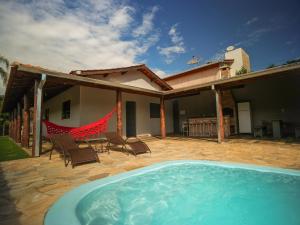 a patio with a hot tub and chairs and a house at Recanto do entardecer in Socorro