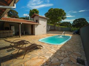 a swimming pool in a yard with chairs and a house at Recanto do entardecer in Socorro